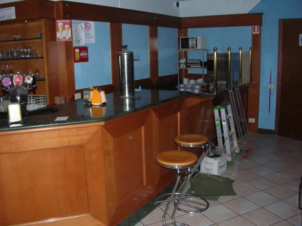 Bancone bar con tavolini e attrezzature